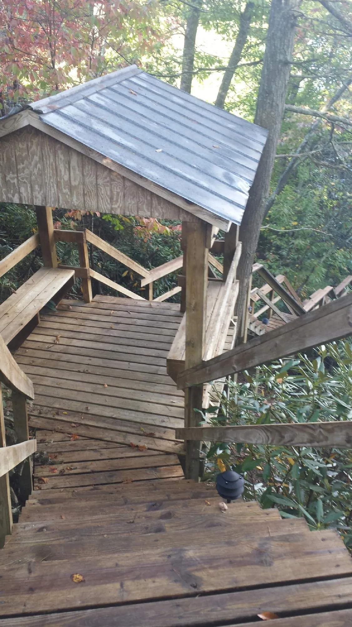 Metal roofed shelter over wooden steps on a wooded walkway — Skylight Repair & Installation work by our crew in Kittanning
