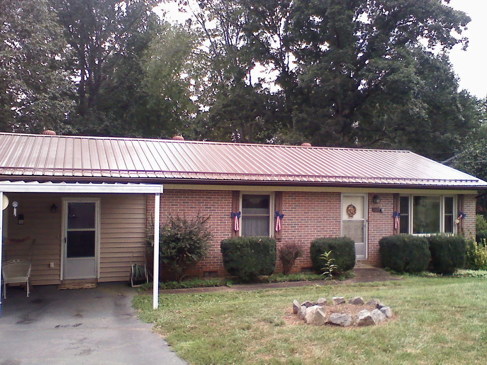 Bronze metal roof and carport on a brick ranch home — Roof Repair work by our crew in Kittanning